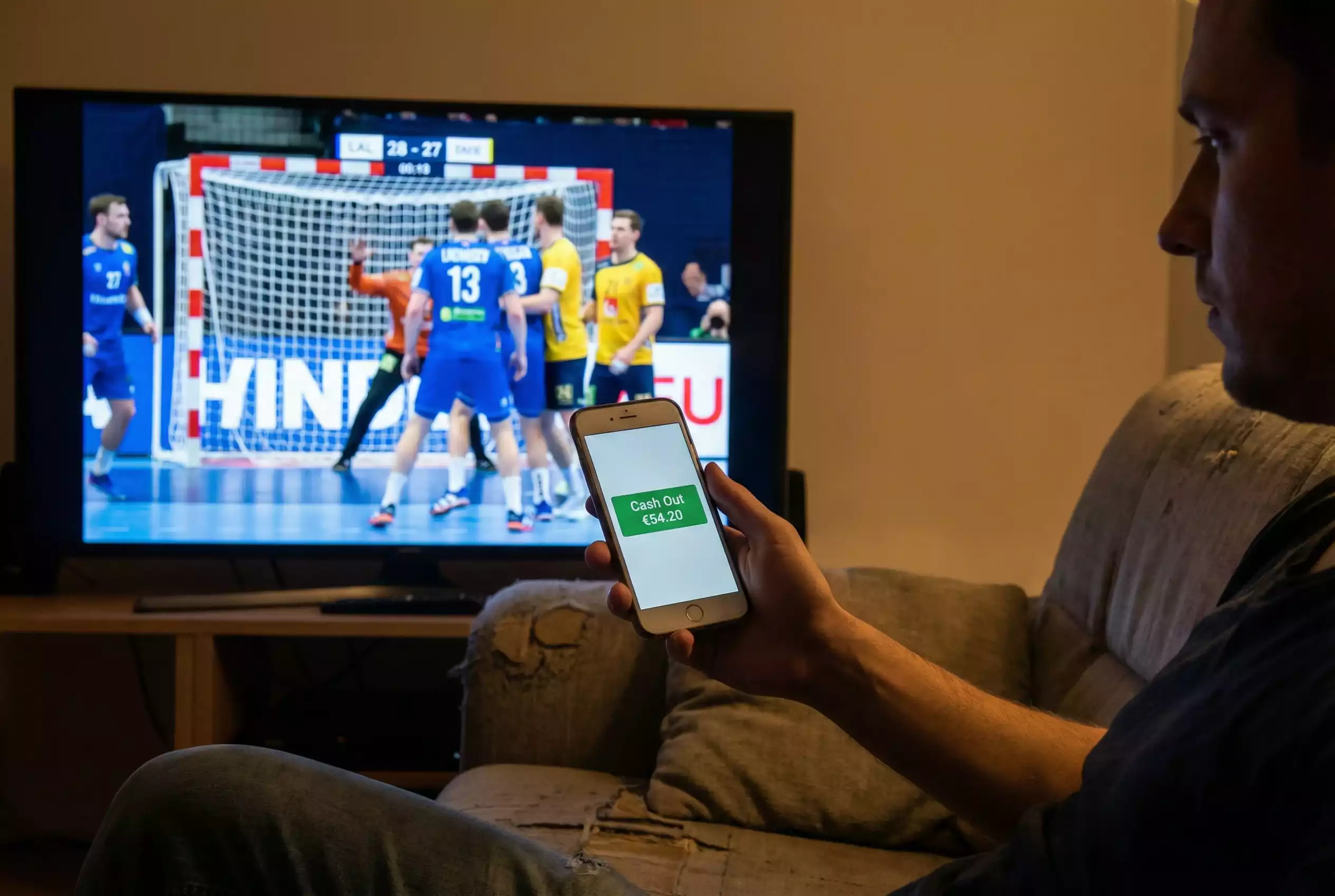 Cash Out Handball Wetten: Smartphone zeigt Cash-Out-Option während eines Spiels